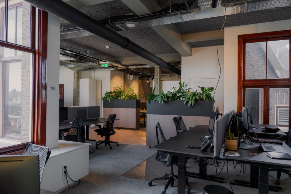 Contemporary office space with desks and plants in Amsterdam.